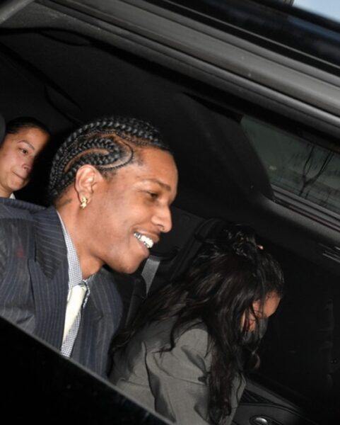 ASAP Rocky uniewinniony – raper siedzi w samochodzie, uśmiechając się szeroko po opuszczeniu sądu w Los Angeles. Obok niego Rihanna, ubrana w szary garnitur, pochyla głowę. W tle inna pasażerka. Scena oddaje atmosferę ulgi po ogłoszeniu wyroku.