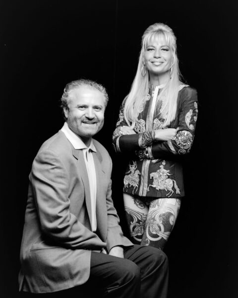 Czarno-białe zdjęcie uśmiechniętej Donatelli Versace i jej brata Gianniego Versace.