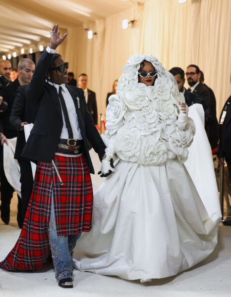 Rihanna w zachwycającej białej sukni Valentino, całkowicie pokrytej trójwymiarowymi kwiatami w kształcie róż, towarzyszy A$AP Rocky’emu ubranemu w szkocki kilt, dżinsy z ćwiekami i czarną marynarkę – para przyciąga spojrzenia na Met Gali 2023.
