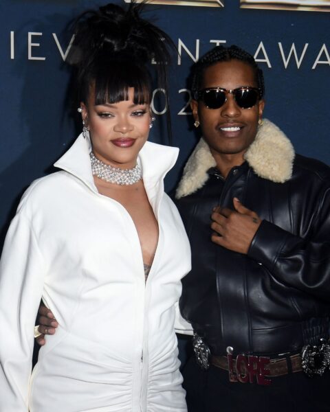 Rihanna i jej partner ASAP Rocky. Rihanna ma na sobie białą sukienkę szmizjerkę, lśniącą kolię oraz kok z grzywką. Obok niej ASAP Rocky ma na sobie skórzaną kurtkę pilotkę z kożuchem oraz okulary przeciwsłoneczne.