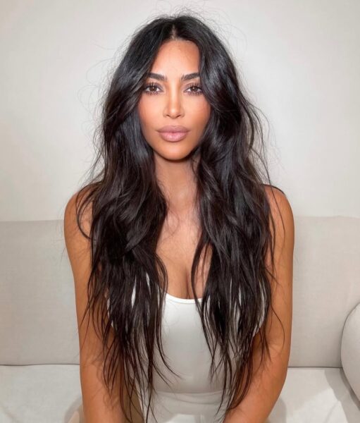 Kim Kardashian w długich, ciemnych i postrzępionych włosach. To jedno z najmodniejszych cięć na lato 2025.