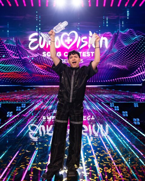 Zwycięzca Eurowizji 2025 ze szklaną statuetką na scenie konkursu.