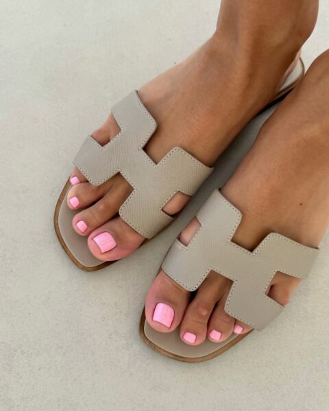 Liliowy pedicure na pięknie opalonych stopach w klapkach Hermes. Pedicure na czerwiec 2025
